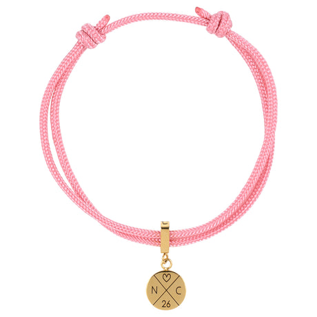 Segeltau Gravur Armband mit persönlicher Gravur. Goldenes Edelstahl Plättchen auf einem rosa Surfer Armband 